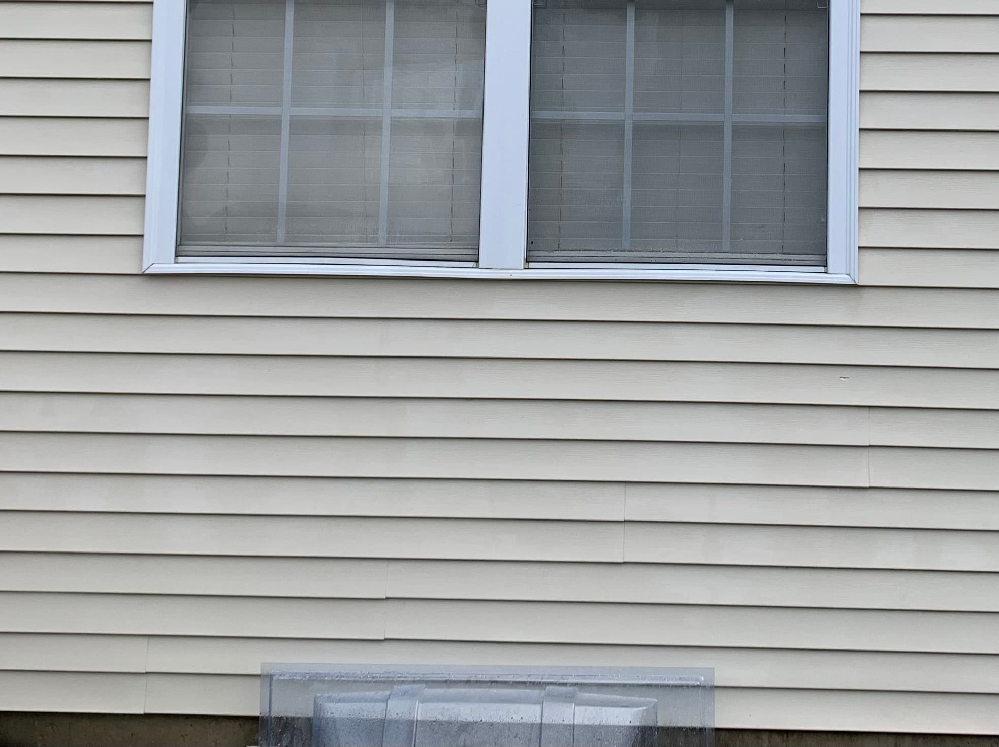Hobart home shows freshly cleaned vinyl siding under a window after professional House Washing removed grime and stains.