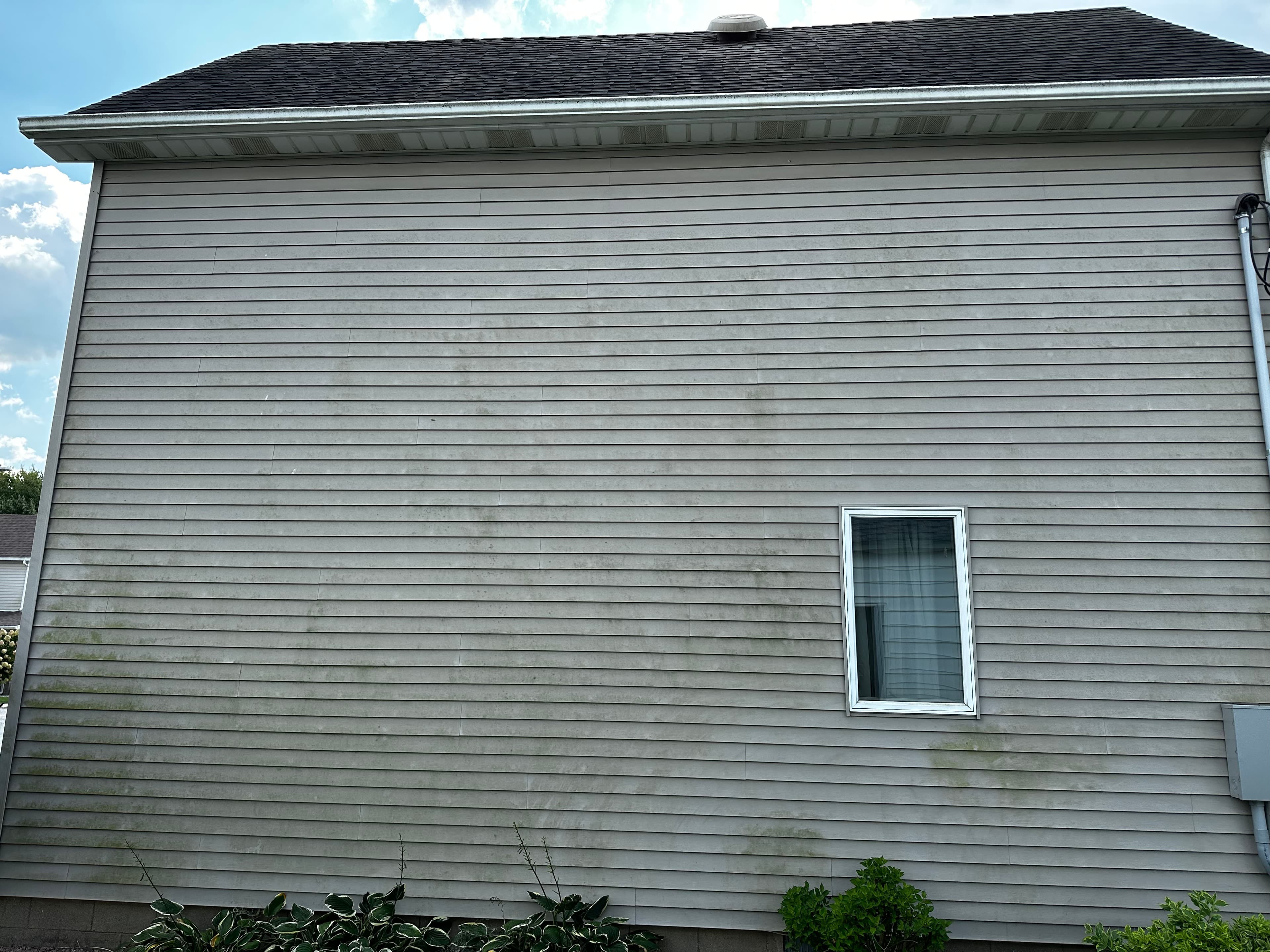 House Washing project in Demotte displaying a wide section of siding with grime accumulation.