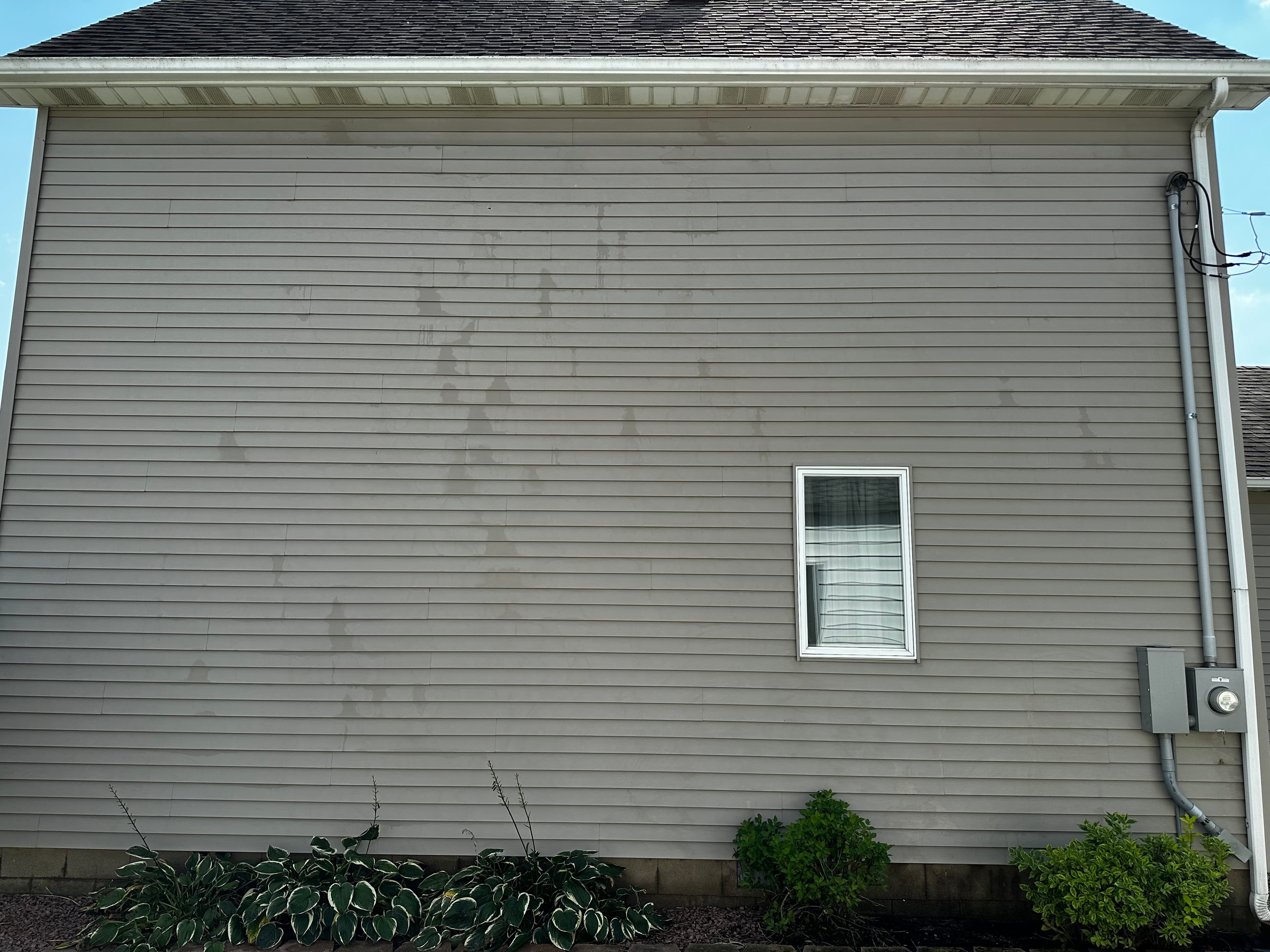 Demotte house with vinyl siding showing signs of weathering and stains before House Washing.