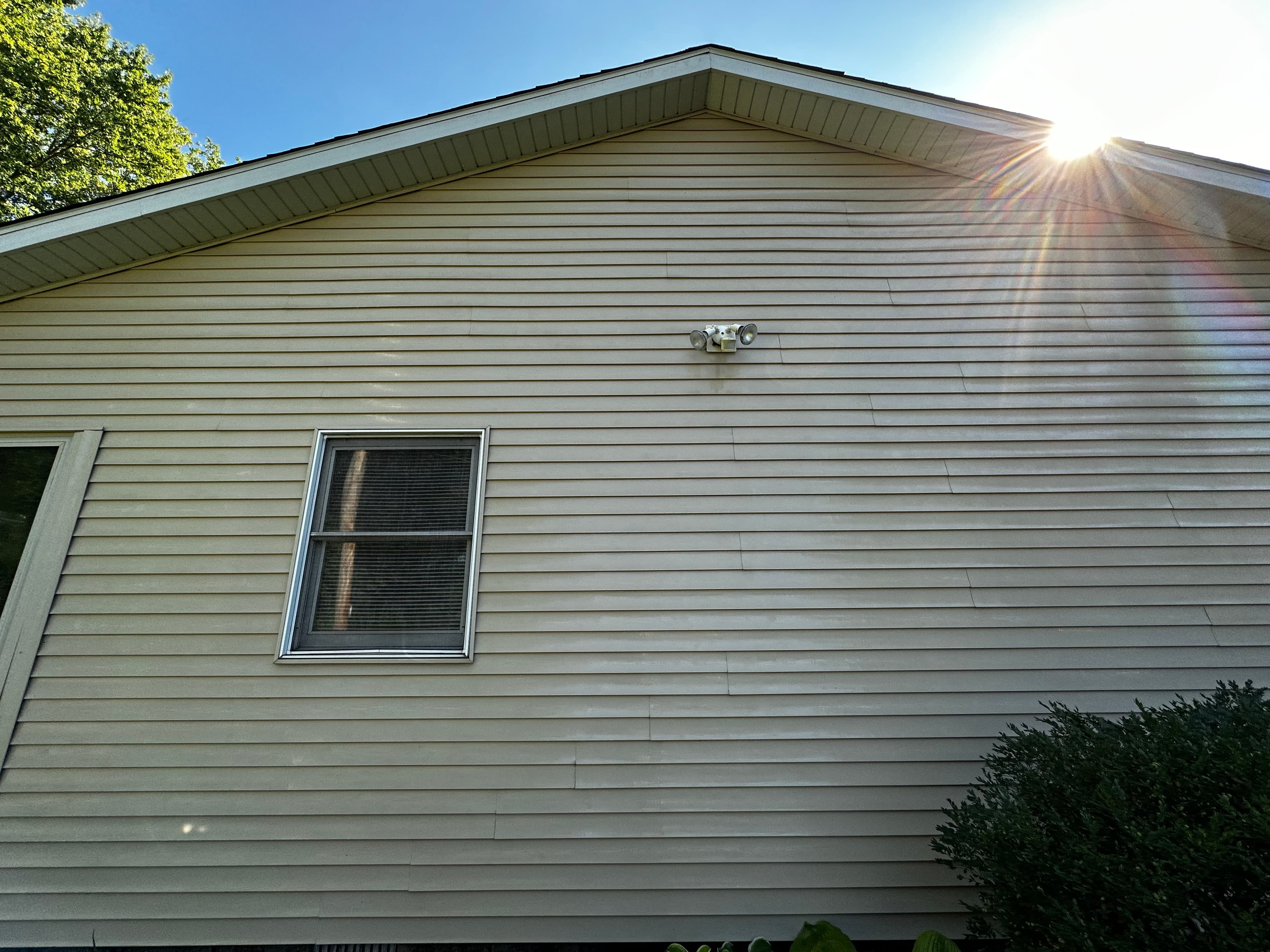Sunlit clean siding after house washing in Crown Point, with a focus on the radiant exterior surface.