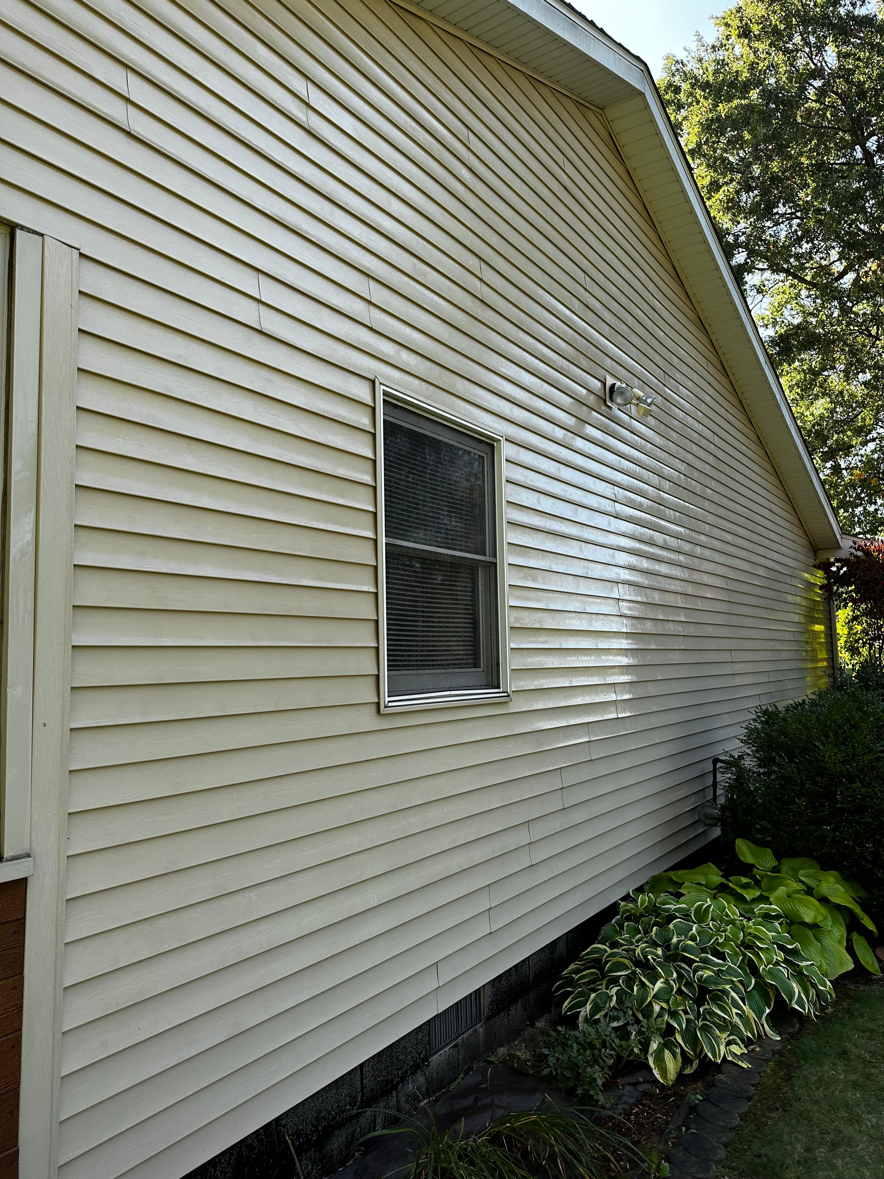 Side view of freshly cleaned siding after house washing in Crown Point, emphasizing the restored appearance.