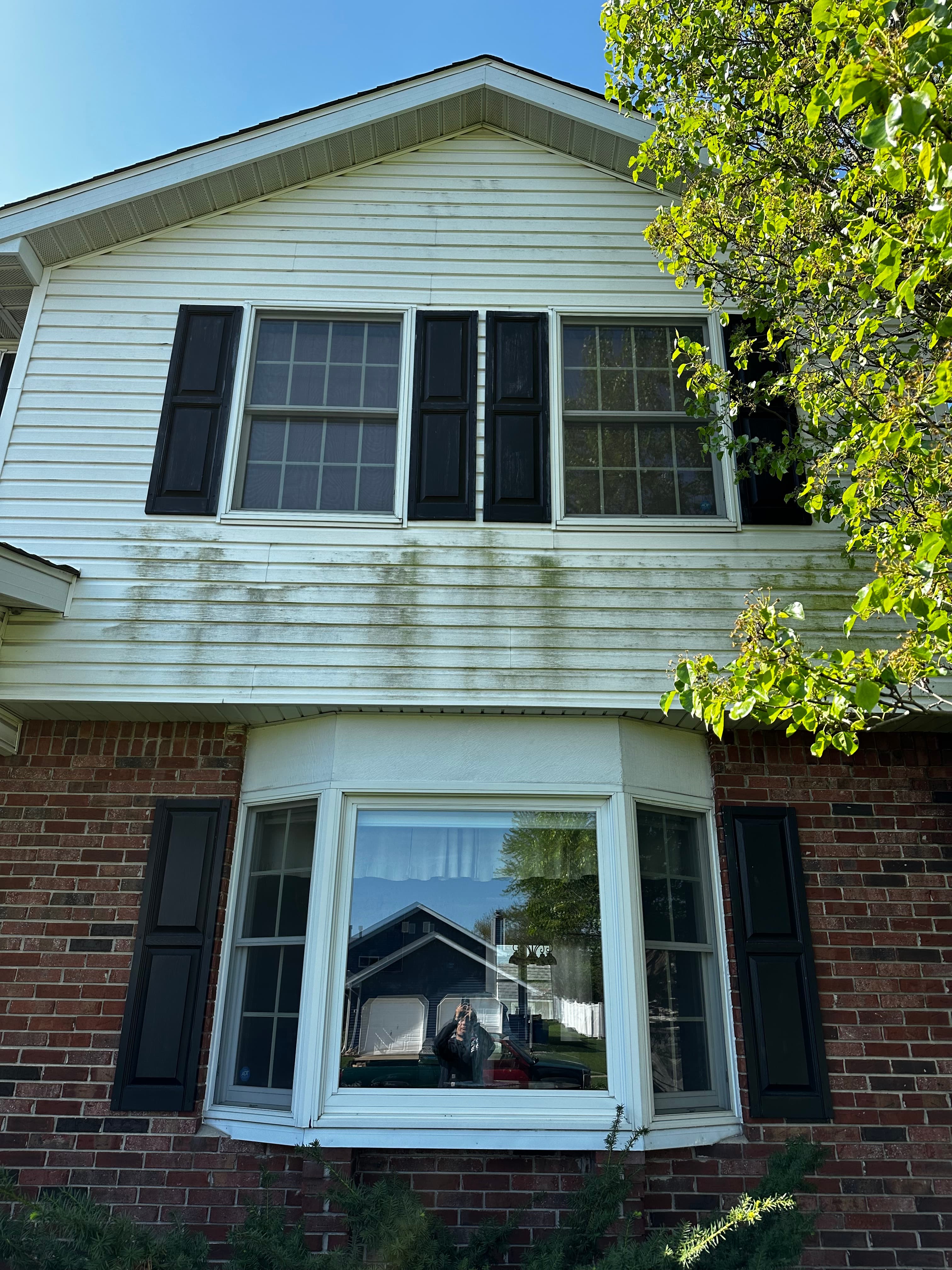 House Washing in Valparaiso showing a two-story home with clean white siding and dark shutters.