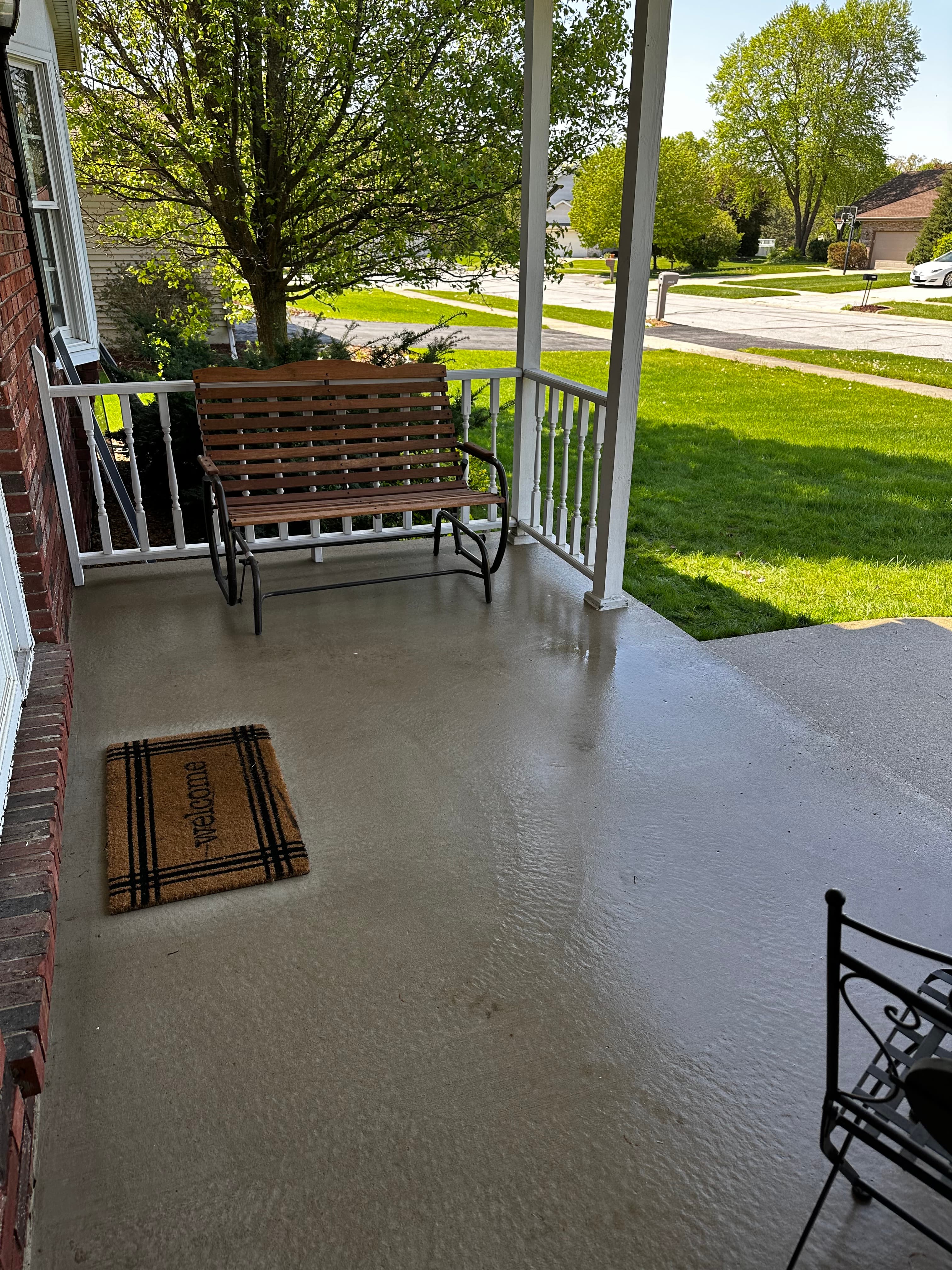 View of a pristine front porch in Valparaiso, showcasing pressure-washed concrete and green lawn.