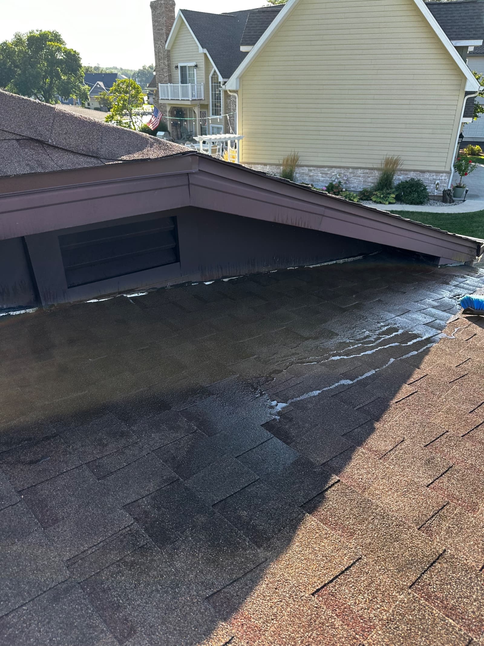 Gutter cleaning in progress on a shingle roof in Rensselaer, Indiana.