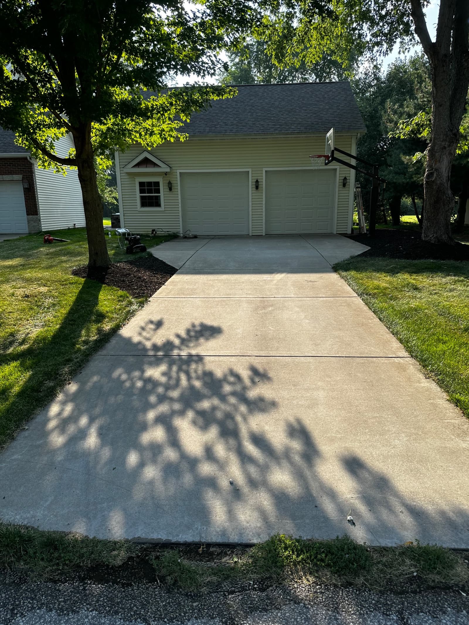 Clean concrete driveway leading to a garage in Wheatfield, Indiana.