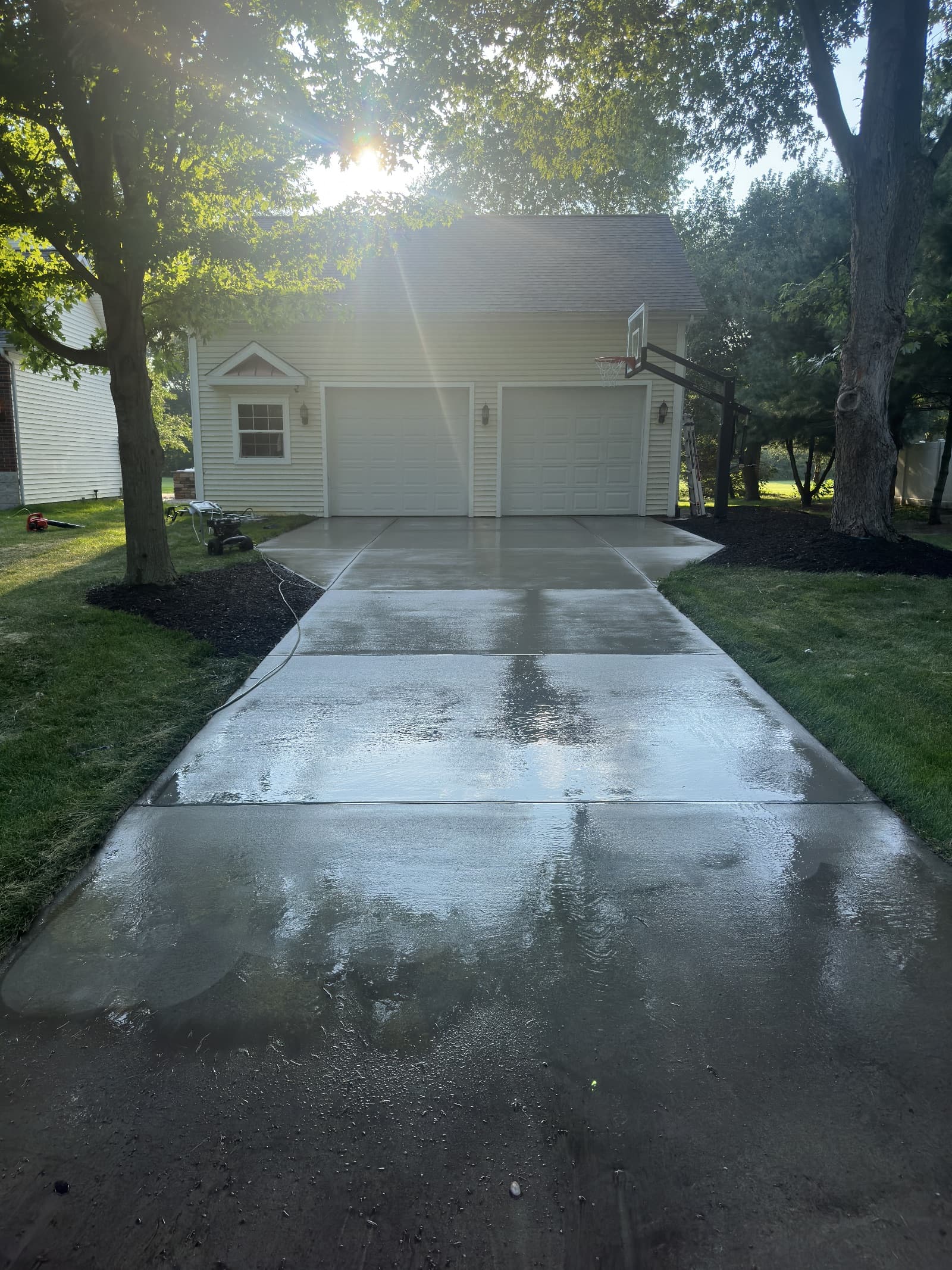 Clean concrete driveway with wet surface in Wheatfield, Indiana