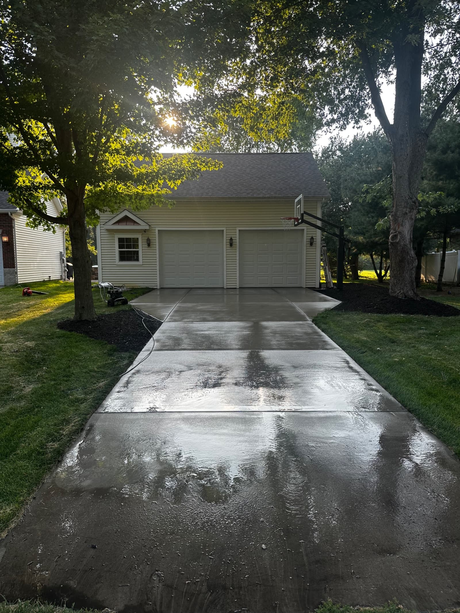 Clean concrete driveway with wet surface in Wheatfield, Indiana