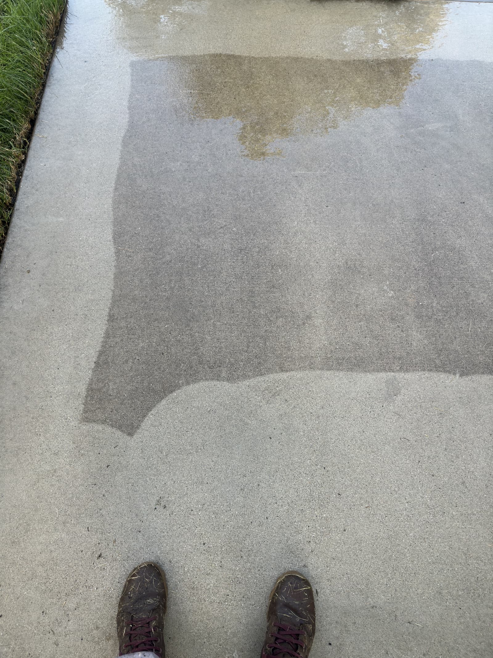 Concrete driveway partially cleaned showing clear contrast