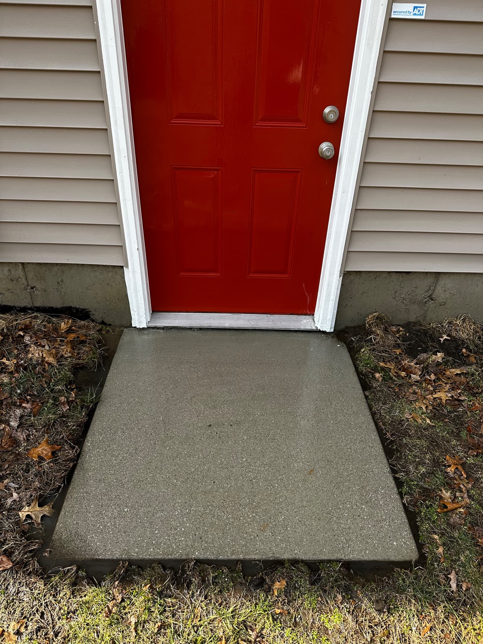 Clean concrete walkway in front of red door, Demotte, Indiana