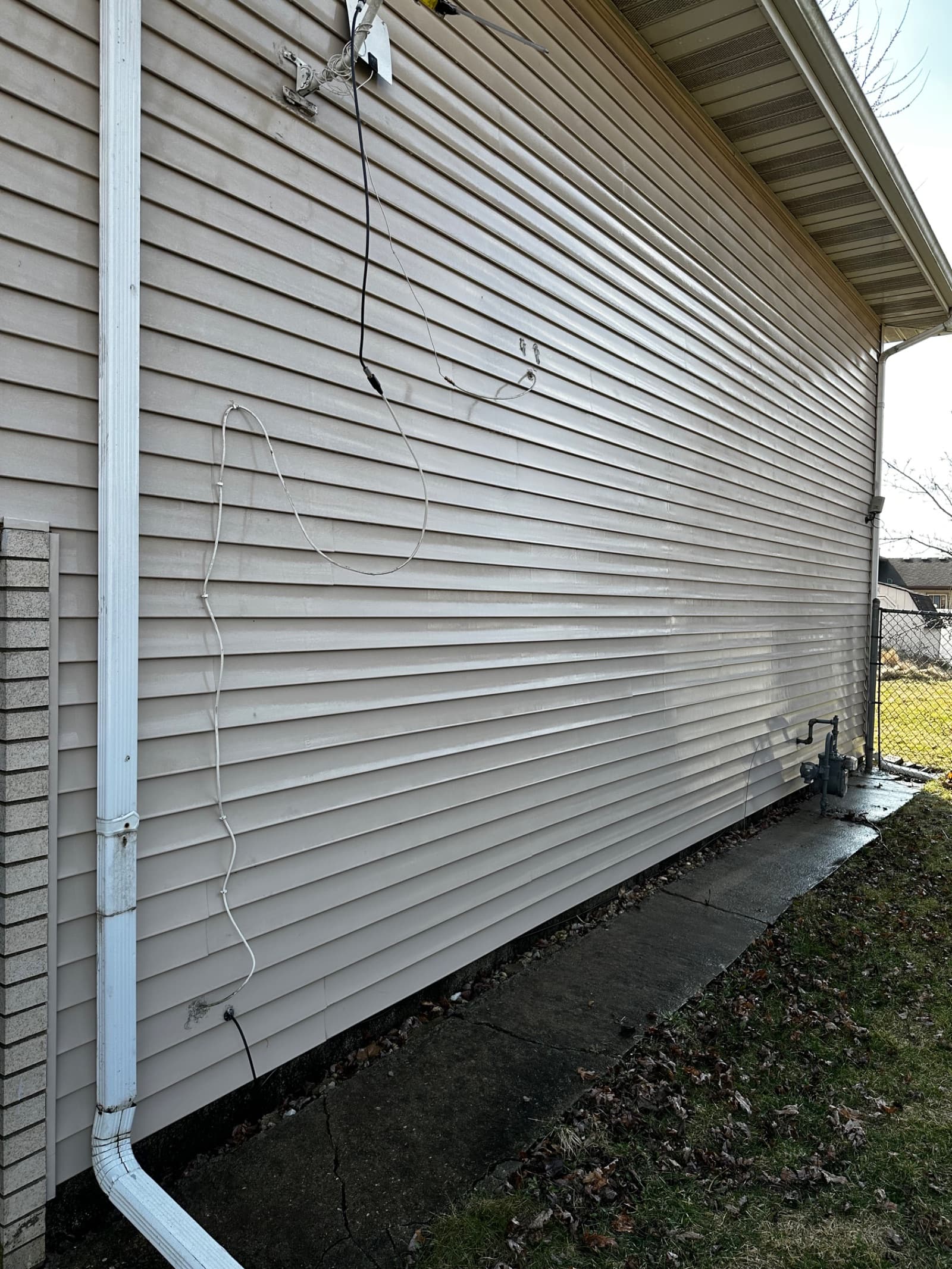 Vinyl siding with visible dirt and stains before cleaning in Demotte, Indiana.