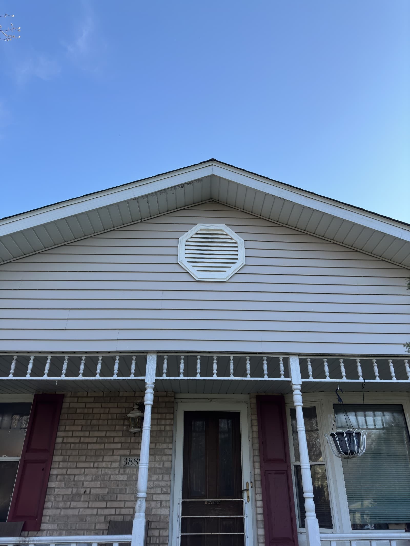 Clean vinyl siding on house gable with clear sky
