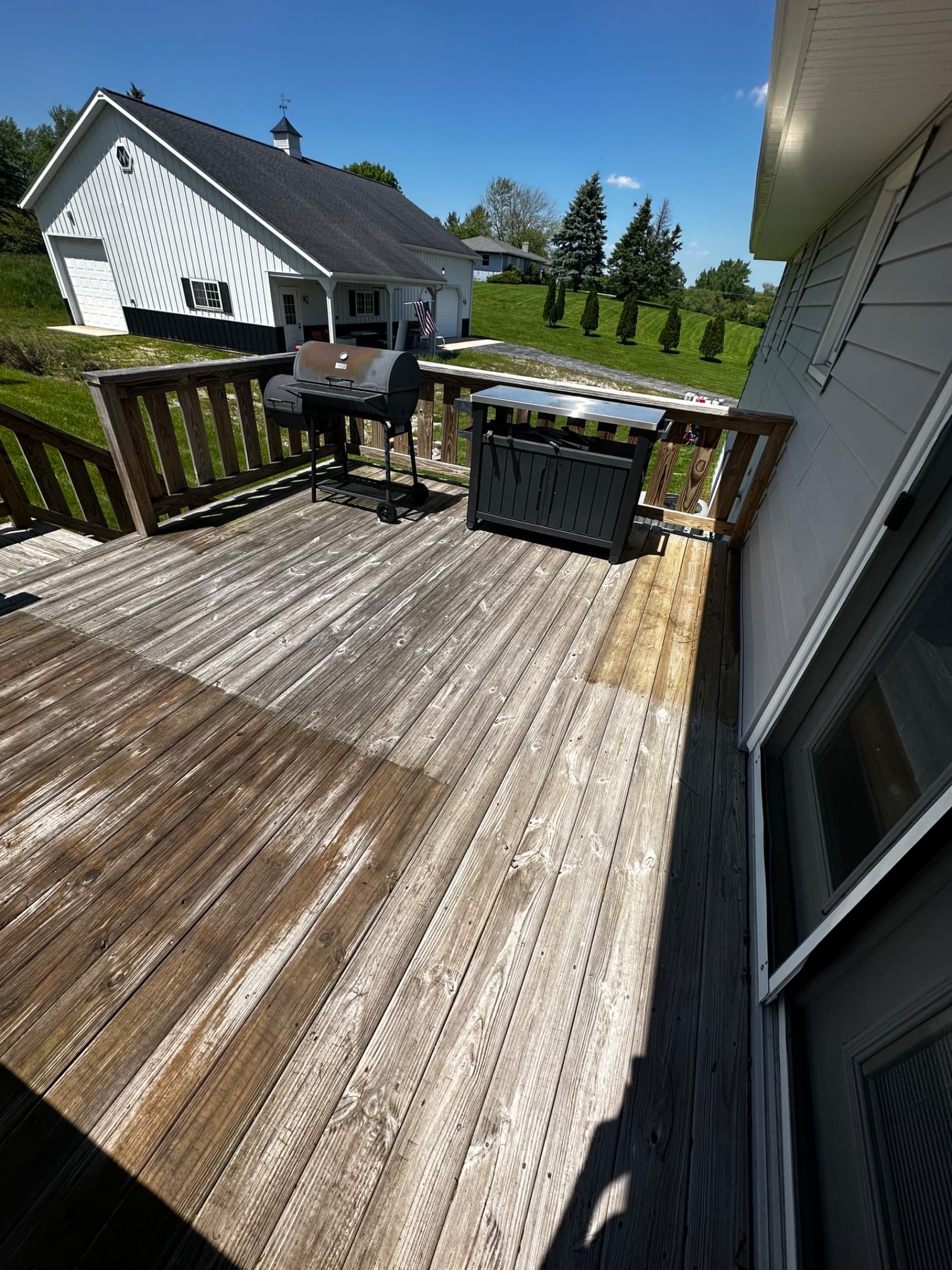 Wooden deck with visible weathering and discoloration in sunlight