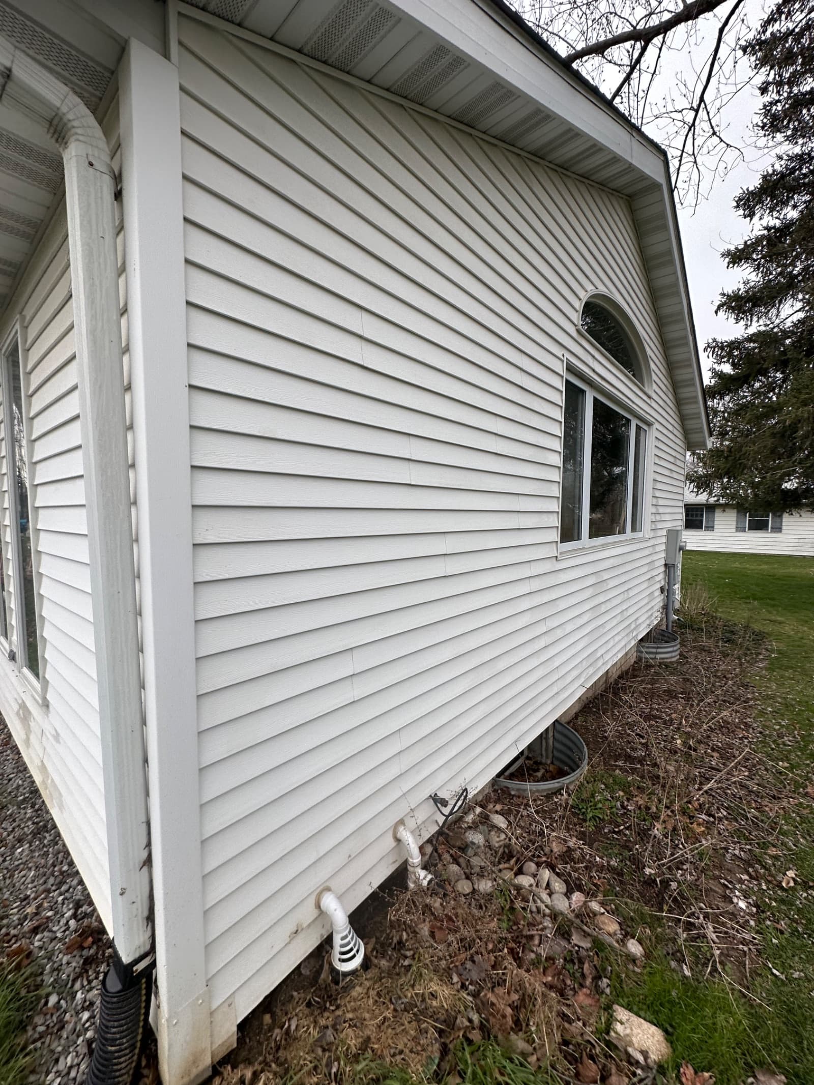 White vinyl siding on house with visible dirt and grime