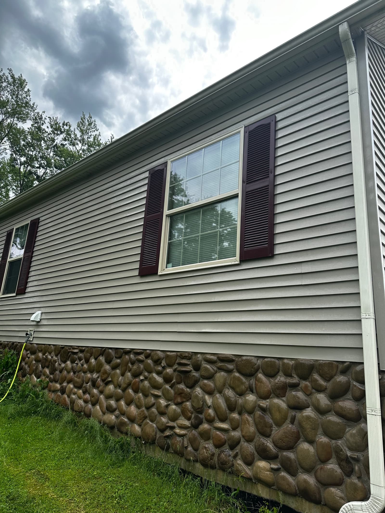 Clean vinyl siding and stone foundation on house in Lowell, Indiana
