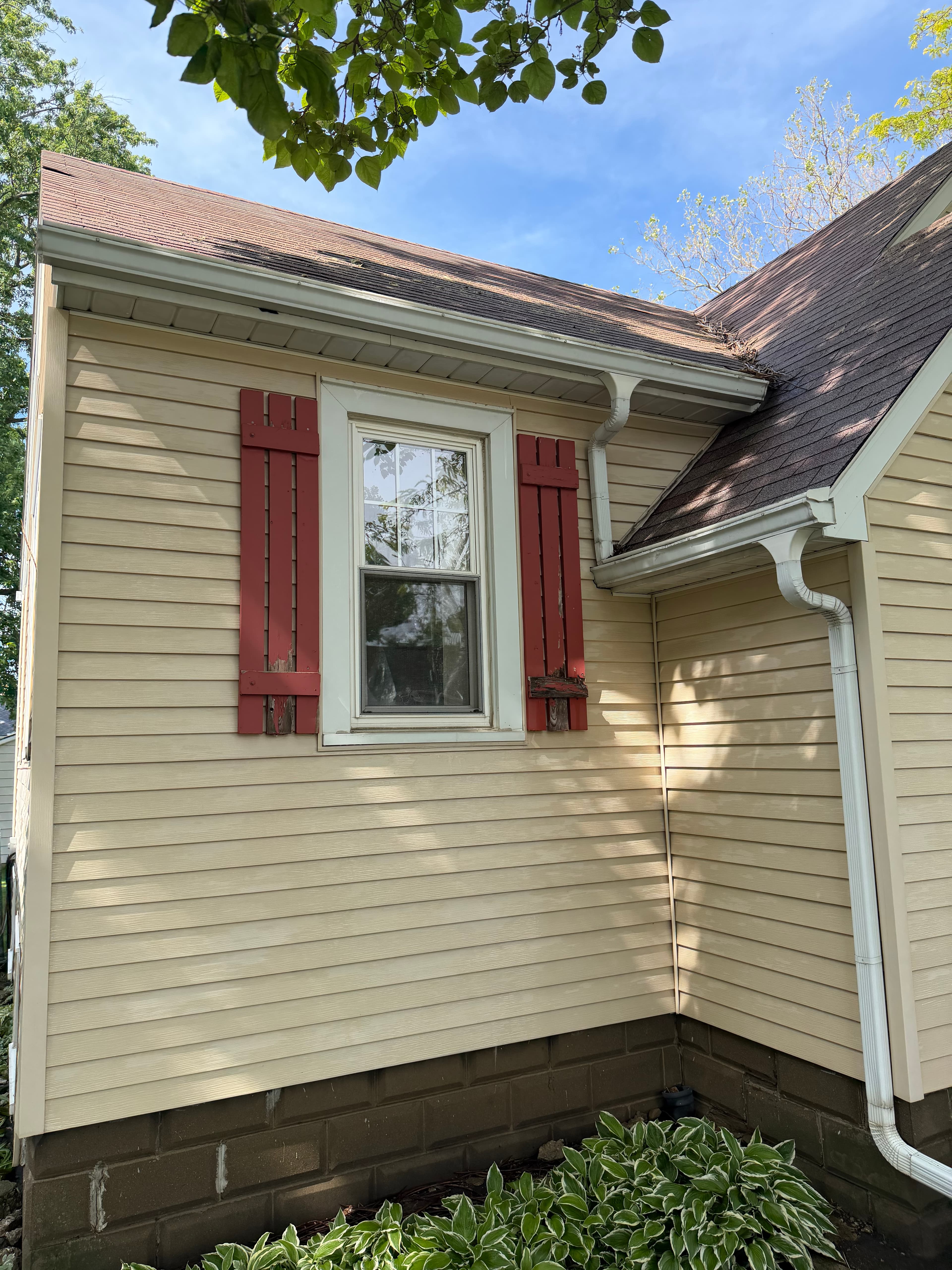 Roof cleaning in progress on a house in Crown Point, Indiana; visible dirt on shingles.