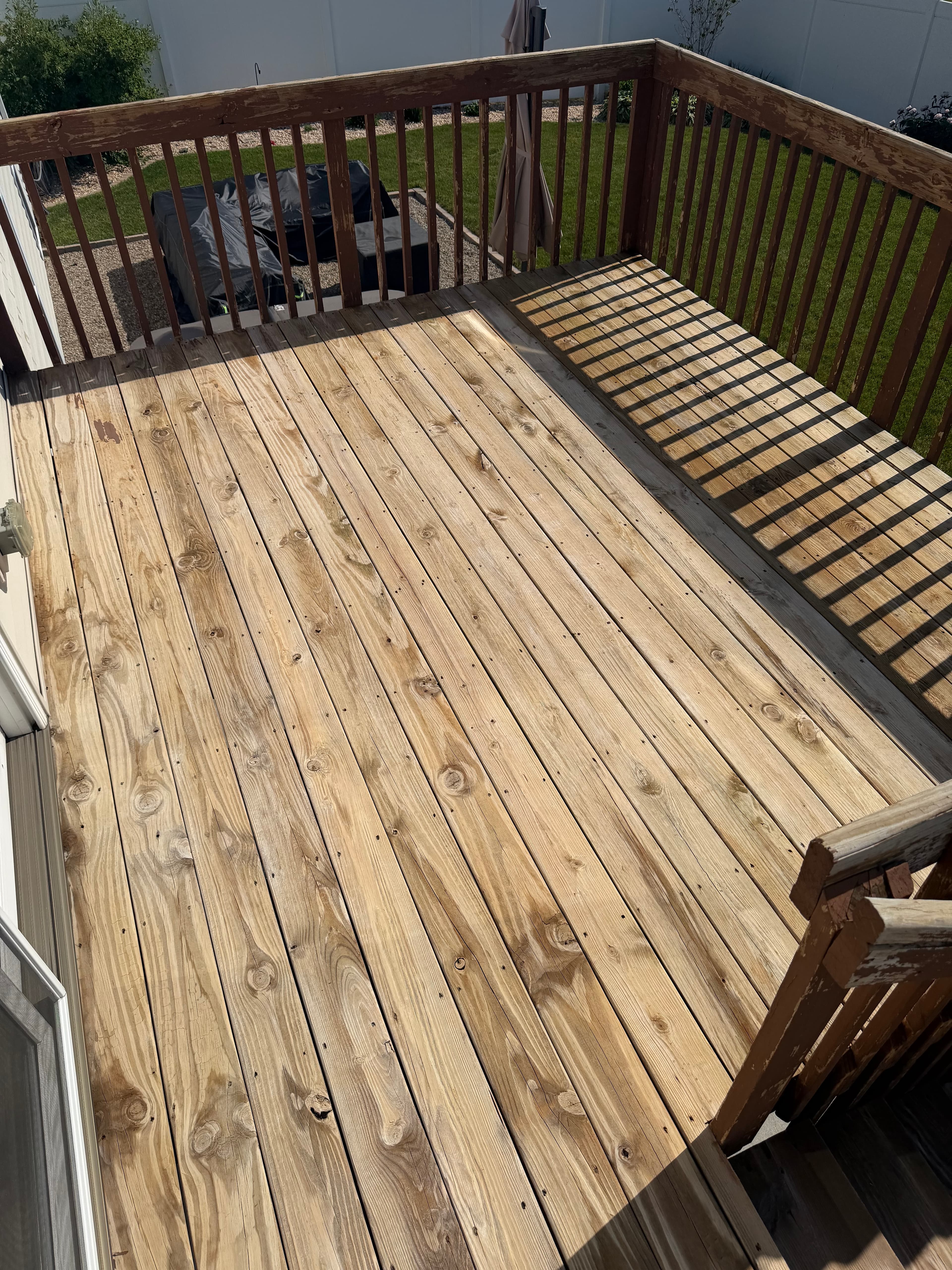 Clean wooden deck after pressure washing, showing bright, refreshed surface; Crown Point, Indiana.