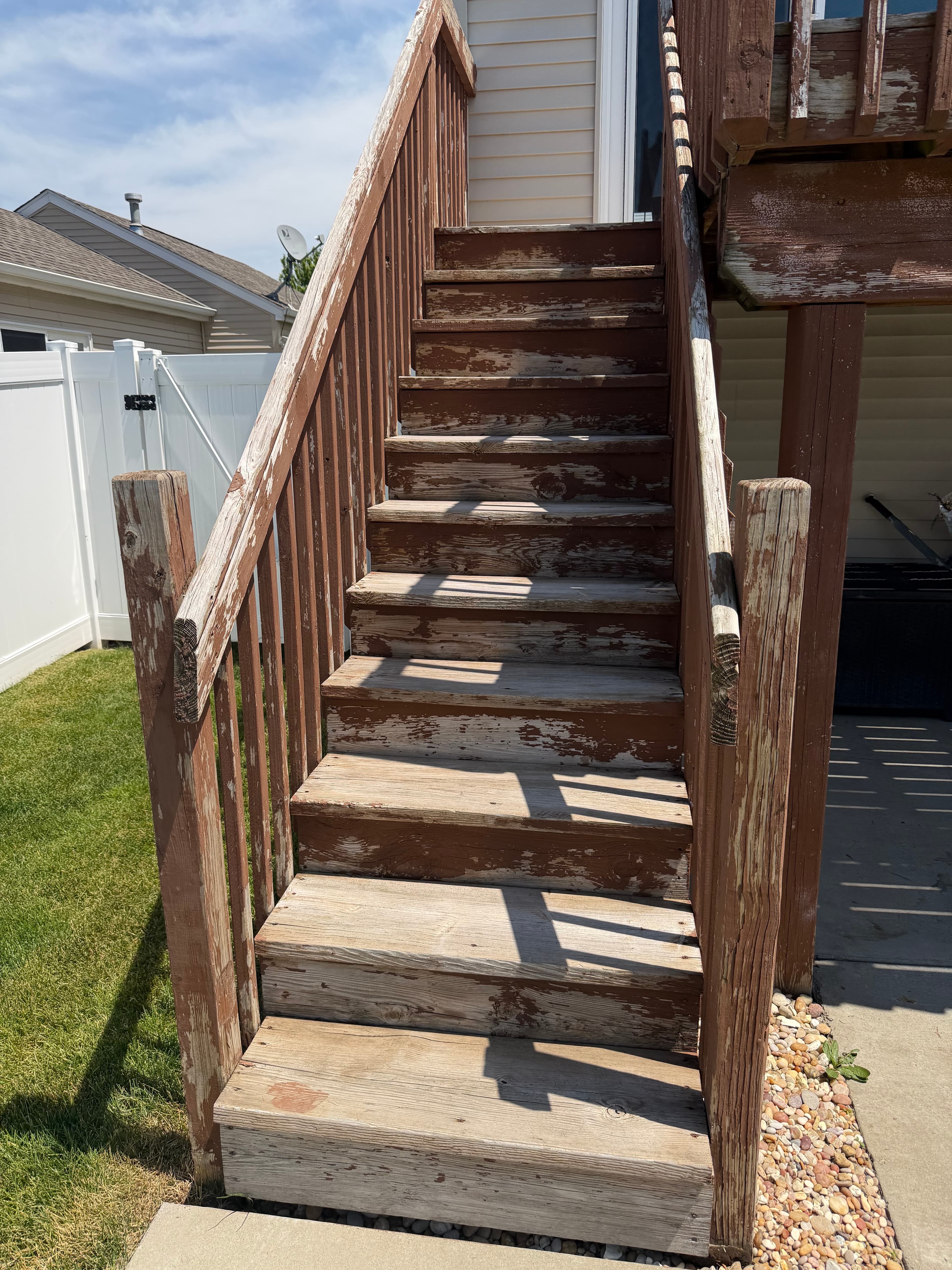 Weathered wooden deck stairs with peeling paint before pressure washing, Crown Point, Indiana.